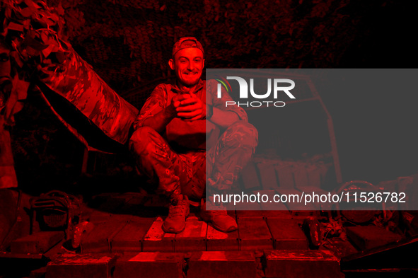 A tanker of the 118th Separate Mechanized Brigade poses for a photo on a T-72 tank during the night firing exercise in the Zaporizhzhia sect...