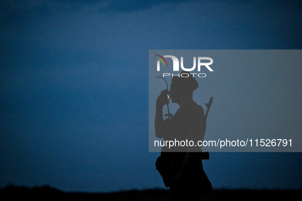 A serviceman of the 118th Separate Mechanized Brigade speaks into the radio during the night firing exercise in the Zaporizhzhia sector in t...