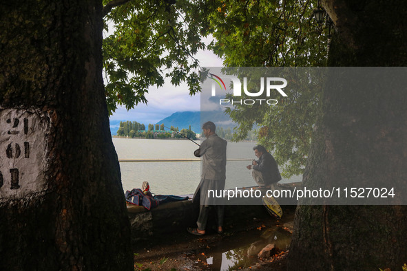 Kashmiris catch fish on the banks of Dal Lake in Srinagar, Jammu and Kashmir, on August 30, 2024. 