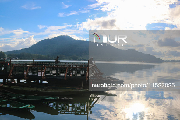 A Kashmiri man fishes on the banks of Dal Lake in Srinagar, Jammu and Kashmir, on August 30, 2024. 