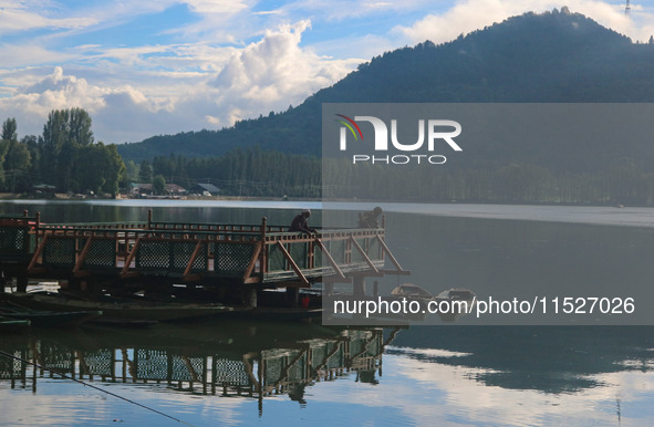 A Kashmiri man fishes on the banks of Dal Lake in Srinagar, Jammu and Kashmir, on August 30, 2024. 