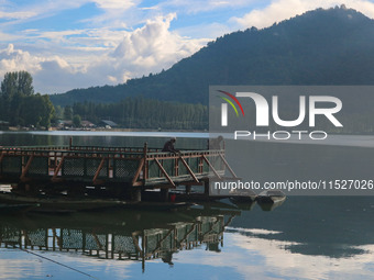 A Kashmiri man fishes on the banks of Dal Lake in Srinagar, Jammu and Kashmir, on August 30, 2024. (