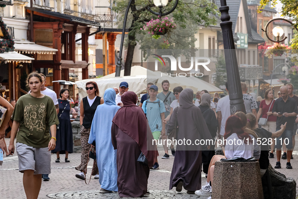 Families walk on a landmark Krupowki Street in the center of Zakopane, a popular Tatra mountain holiday resort on the last weekend of school...