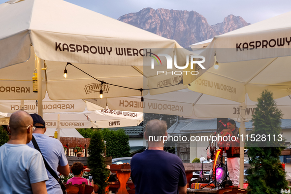 People rest in a bar on a landmark Krupowki Street in the center of Zakopane, a popular Tatra mountain holiday resort on the last weekend of...