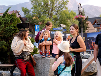 Family talk with a man dressed traditionally in Janosik style on a landmark Krupowki Street in the center of Zakopane, a popular Tatra mount...