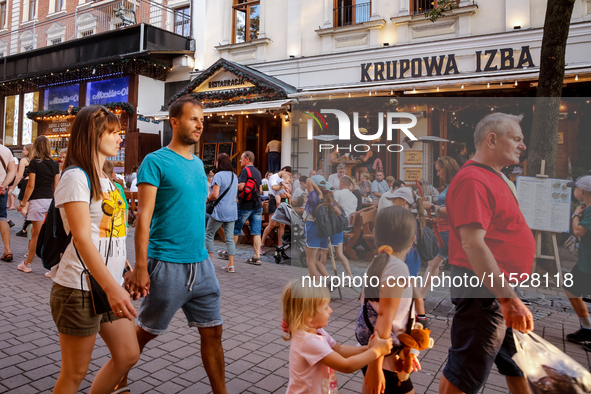 Families walk on a landmark Krupowki Street in the center of Zakopane, a popular Tatra mountain holiday resort on the last weekend of school...