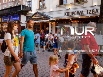 Families walk on a landmark Krupowki Street in the center of Zakopane, a popular Tatra mountain holiday resort on the last weekend of school...