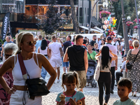 Families walk on a landmark Krupowki Street in the center of Zakopane, a popular Tatra mountain holiday resort on the last weekend of school...