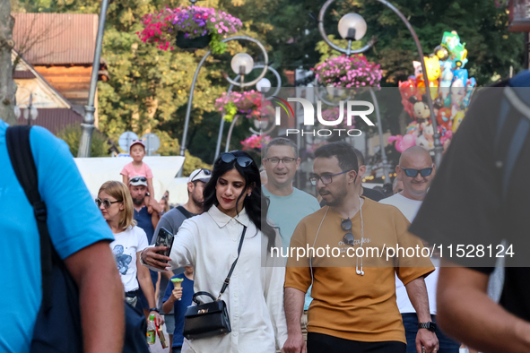 Families walk on a landmark Krupowki Street in the center of Zakopane, a popular Tatra mountain holiday resort on the last weekend of school...