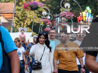 Families walk on a landmark Krupowki Street in the center of Zakopane, a popular Tatra mountain holiday resort on the last weekend of school...