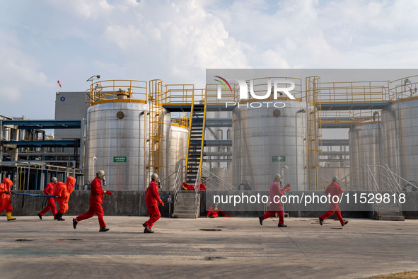 Workers are evacuated at the site of an emergency drill for hazardous chemical production safety accidents at a chemical park in Hefei, Chin...