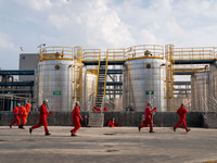 Workers are evacuated at the site of an emergency drill for hazardous chemical production safety accidents at a chemical park in Hefei, Chin...