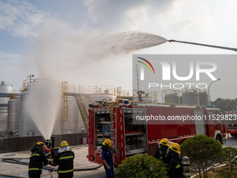 Firefighters fight a fire at the site of an emergency drill for hazardous chemicals production in a chemical park in Hefei, China, on August...