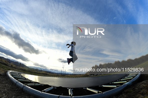 A little girl, Minudi Menulya, jumps on a trampoline in Twizel, New Zealand, on August 30, 2024. 