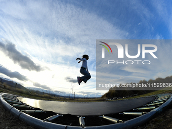 A little girl, Minudi Menulya, jumps on a trampoline in Twizel, New Zealand, on August 30, 2024. (