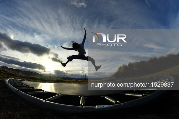 A little girl, Minudi Menulya, jumps on a trampoline in Twizel, New Zealand, on August 30, 2024. 