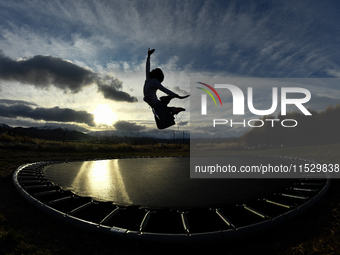 A little girl, Minudi Menulya, jumps on a trampoline in Twizel, New Zealand, on August 30, 2024. (