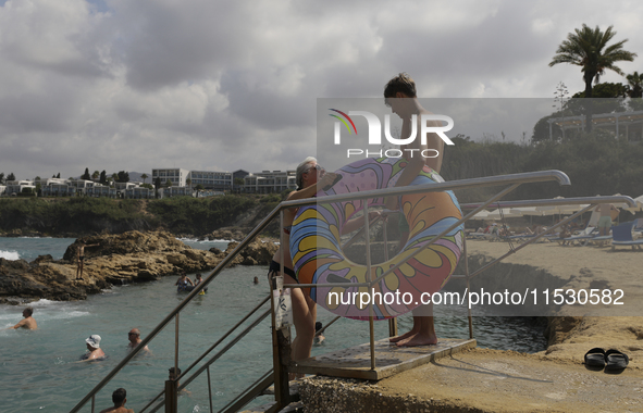 Tourists relax near a hotel near Paphos. Cyprus, Saturday, August 31, 2024. Today is the end of summer, but according to tour operators, hot...