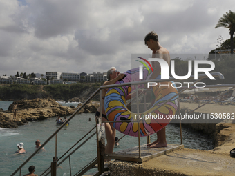 Tourists relax near a hotel near Paphos. Cyprus, Saturday, August 31, 2024. Today is the end of summer, but according to tour operators, hot...