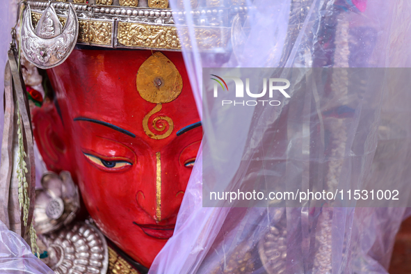 A statue of Dipankar Buddha is covered with plastic sheets after it rains during the annual Panchadan festival in Bhaktapur, Nepal, on Augus...