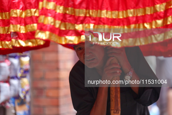 A Nepali devotee holds the umbrella for the statues of Dipankar Buddha during the Panchadan festival in Bhaktapur, Nepal, on August 31, 2024...