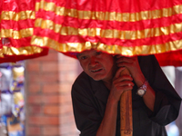 A Nepali devotee holds the umbrella for the statues of Dipankar Buddha during the Panchadan festival in Bhaktapur, Nepal, on August 31, 2024...