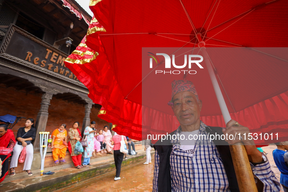 A Nepali devotee holds the umbrella for the statues of Dipankar Buddha during the Panchadan festival in Bhaktapur, Nepal, on August 31, 2024...