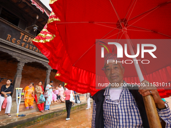 A Nepali devotee holds the umbrella for the statues of Dipankar Buddha during the Panchadan festival in Bhaktapur, Nepal, on August 31, 2024...