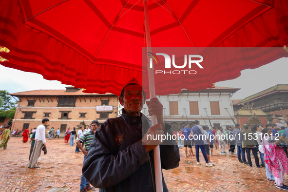 A Nepali devotee holds the umbrella for the statues of Dipankar Buddha during the Panchadan festival in Bhaktapur, Nepal, on August 31, 2024...