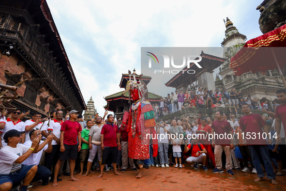 A person performs a ritualistic dance in Bhaktapur Durbar Square, Bhaktapur, Nepal, on August 31, 2024, wearing the statue of one of the Dip...