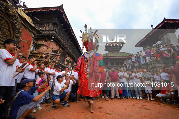 A person performs a ritualistic dance in Bhaktapur Durbar Square, Bhaktapur, Nepal, on August 31, 2024, wearing the statue of one of the Dip...