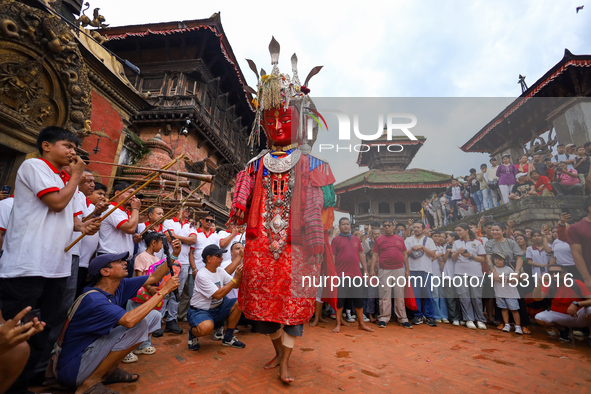 A person performs a ritualistic dance in Bhaktapur Durbar Square, Bhaktapur, Nepal, on August 31, 2024, wearing the statue of one of the Dip...