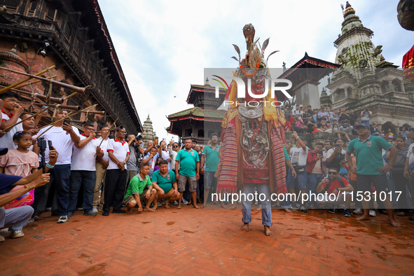 A person performs a ritualistic dance in Bhaktapur Durbar Square, Bhaktapur, Nepal, on August 31, 2024, wearing the statue of one of the Dip...