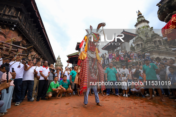 A person performs a ritualistic dance in Bhaktapur Durbar Square, Bhaktapur, Nepal, on August 31, 2024, wearing the statue of one of the Dip...