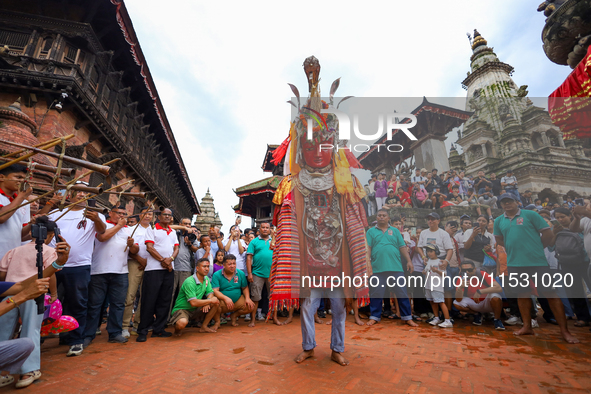 A person performs a ritualistic dance in Bhaktapur Durbar Square, Bhaktapur, Nepal, on August 31, 2024, wearing the statue of one of the Dip...