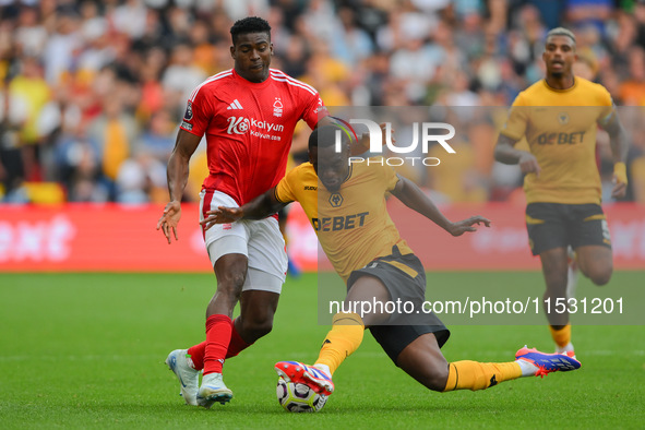 Toti Gomes of Wolverhampton Wanderers tackles Taiwo Awoniyi of Nottingham Forest during the Premier League match between Nottingham Forest a...