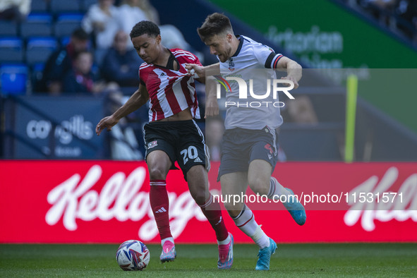 Jack Aitchison #10 of Exeter City F.C. is tackled by George Thomason #4 of Bolton Wanderers F.C. during the Sky Bet League 1 match between B...