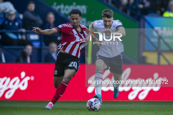 Jack Aitchison #10 of Exeter City F.C. is tackled by George Thomason #4 of Bolton Wanderers F.C. during the Sky Bet League 1 match between B...