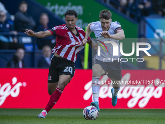 Jack Aitchison #10 of Exeter City F.C. is tackled by George Thomason #4 of Bolton Wanderers F.C. during the Sky Bet League 1 match between B...