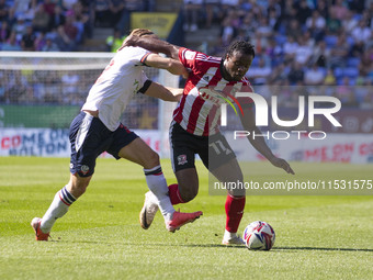 Millenic Alli #11 of Exeter City F.C. is tackled by Kyle Dempsey #22 of Bolton Wanderers F.C. during the Sky Bet League 1 match between Bolt...