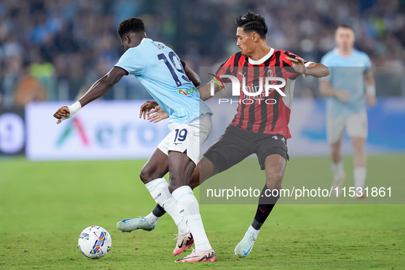 Tijjani Reijnders of AC Milan and Boulaye Dia of SS Lazio compete for the ball during the Serie A Enilive match between SS Lazio and AC Mila...