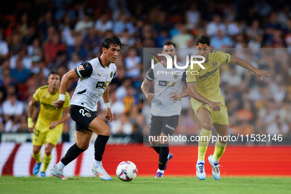 Jesus Vazquez of Valencia CF competes for the ball with Ayoze of Villarreal CF during the LaLiga EA Sports match between Valencia CF and Vil...