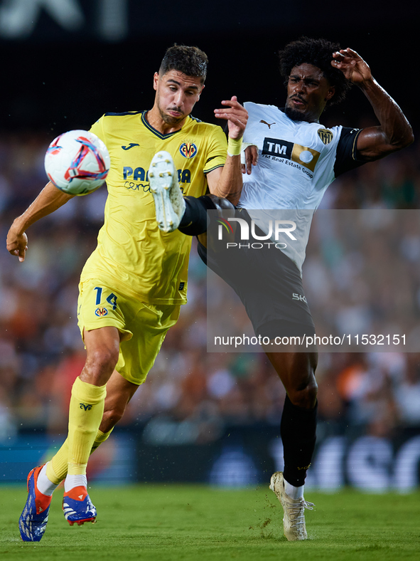 Santi Comesana Veiga of Villarreal CF competes for the ball with Thierry Rendall of Valencia CF during the LaLiga EA Sports match between Va...