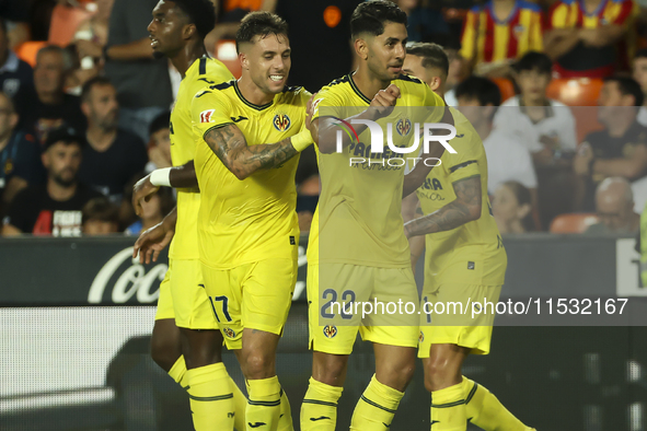 Villarreal's Ayoze Perez Gutierrez celebrates after scoring the 1-1 goal with his teammate during the La Liga match between Valencia CF and...