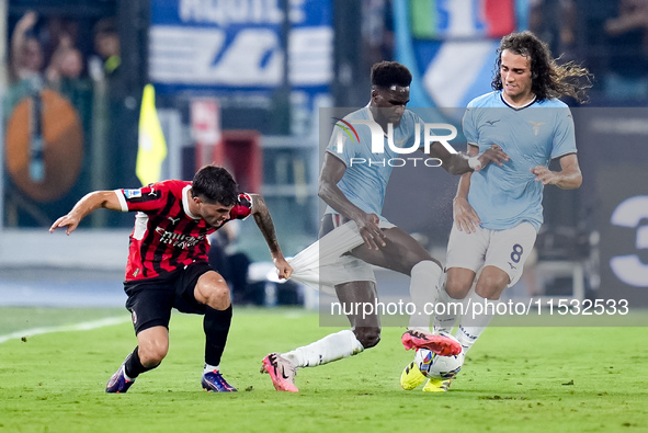 Christian Pulisic of AC Milan and Boulaye Dia of SS Lazio compete for the ball during the Serie A Enilive match between SS Lazio and AC Mila...