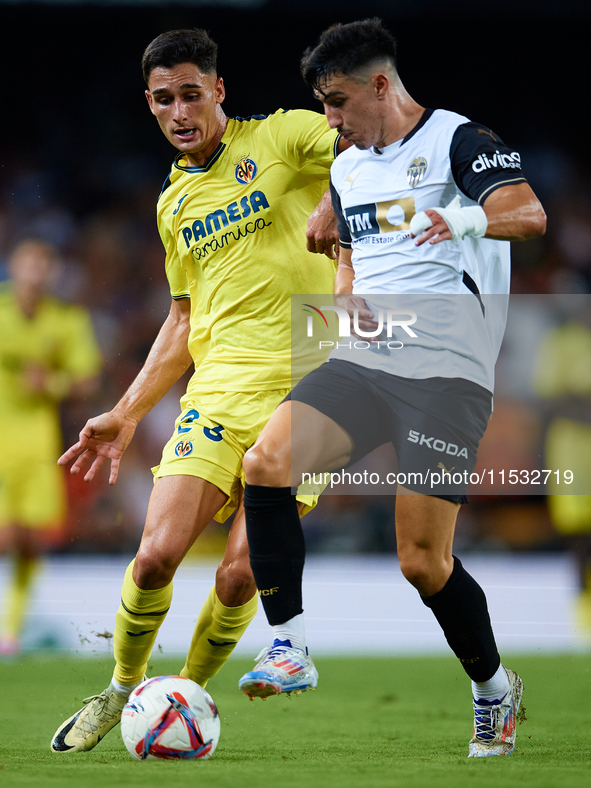 Diego Lopez (R) of Valencia CF competes for the ball with Sergi Cardona of Villarreal CF during the LaLiga EA Sports match between Valencia...