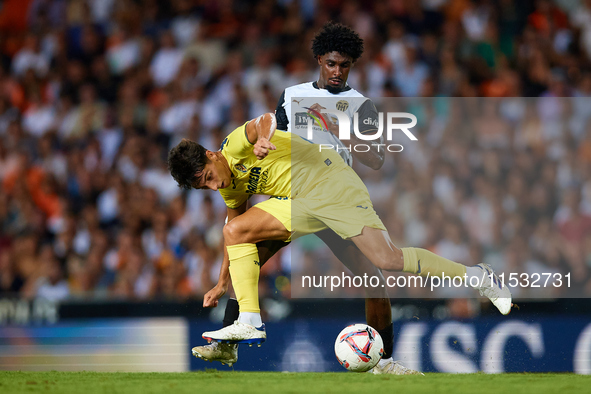 Ramon Terrats of Villarreal CF competes for the ball with Thierry Rendall of Valencia CF during the LaLiga EA Sports match between Valencia...