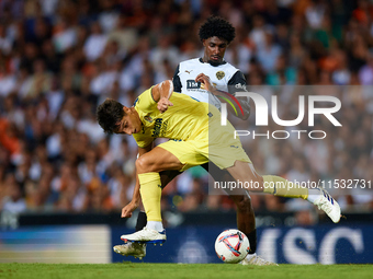 Ramon Terrats of Villarreal CF competes for the ball with Thierry Rendall of Valencia CF during the LaLiga EA Sports match between Valencia...