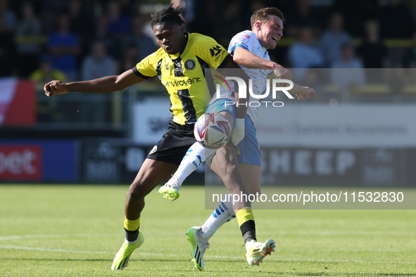 Harrogate Town's Sam Folarin is fouled by Barrow's Robbie Gotts during the Sky Bet League 2 match between Harrogate Town and Barrow at Wethe...