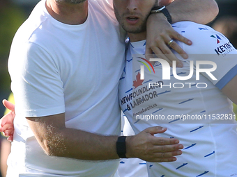 Barrow Manager Stephen Clemence and Barrow's Andrew Dallas embrace at full time during the Sky Bet League 2 match between Harrogate Town and...